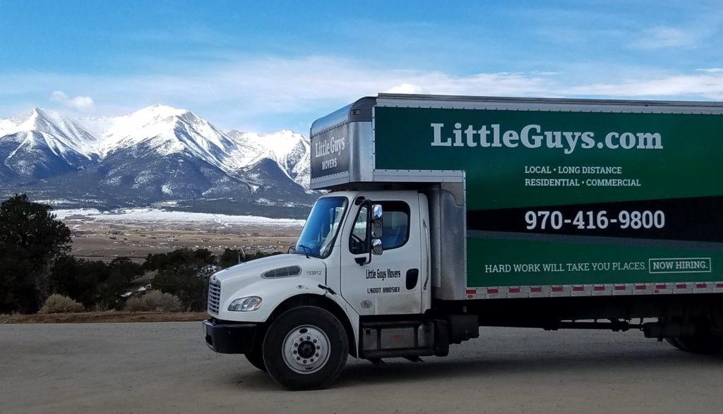 Little Guys truck in front of a snow-capped mountain range
