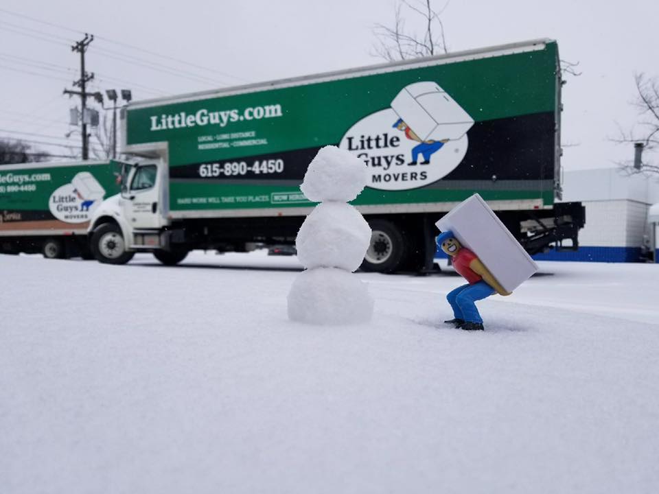 Mike the Mover posing with a tiny snowman in front of a Little Guys truck