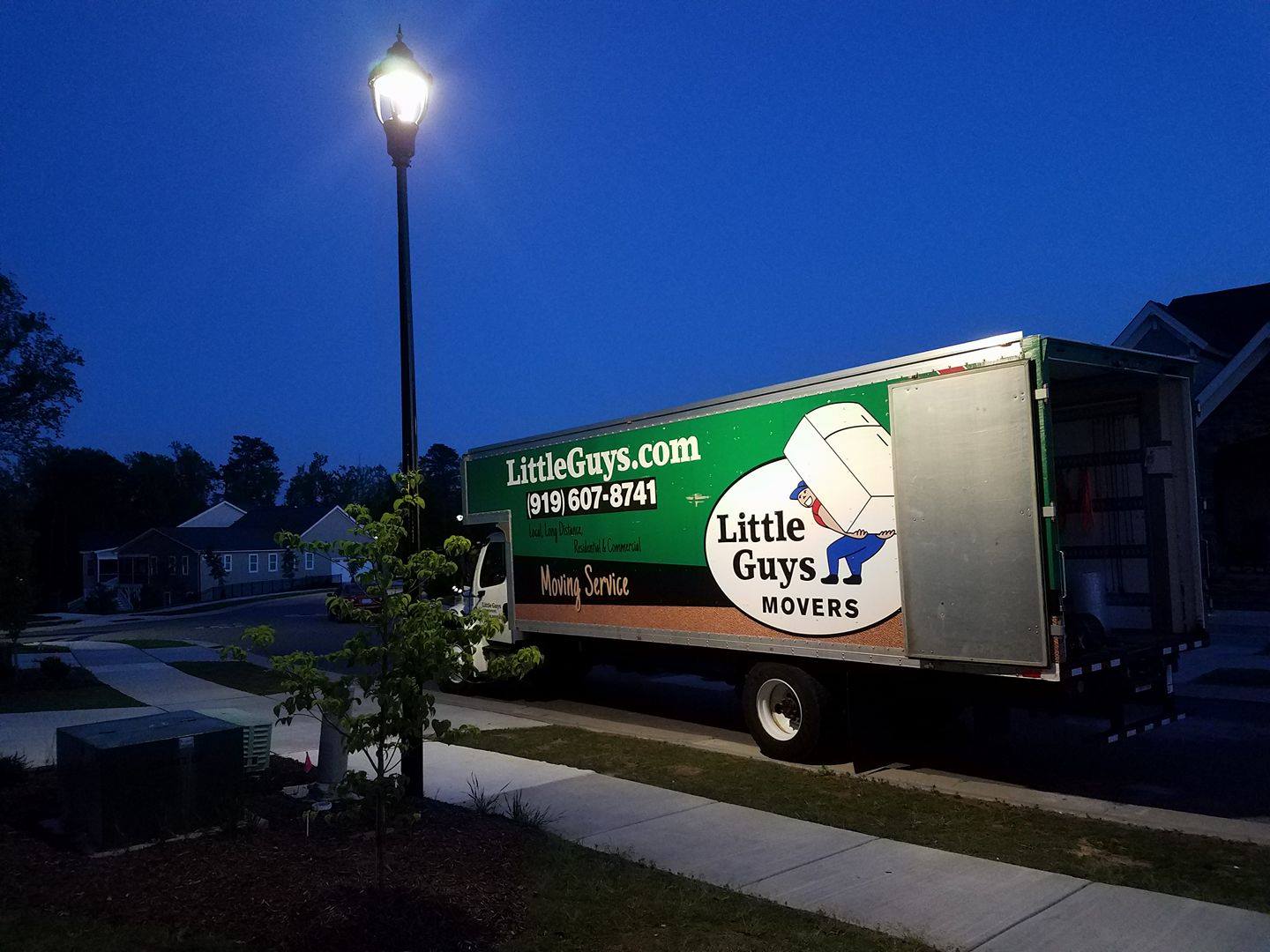 A Little Guys Movers truck outside of a home
