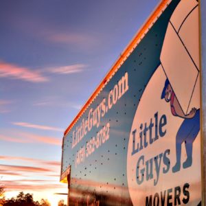 Little Guys Movers truck in front of sunset