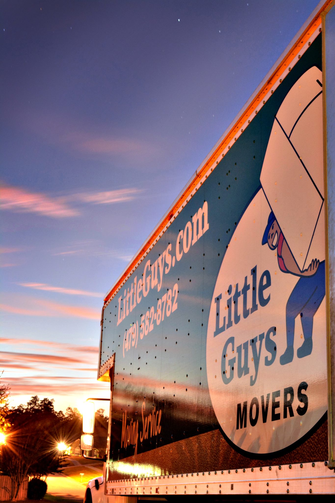 Little Guys Movers truck in front of sunset
