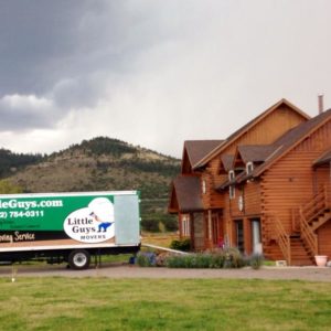 Moving truck next to large cabin