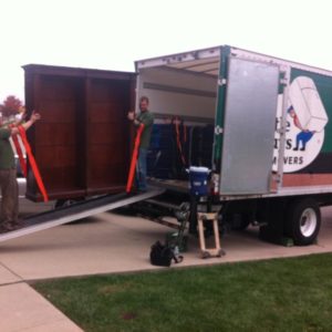 Two movers loading a Little Guys Movers truck