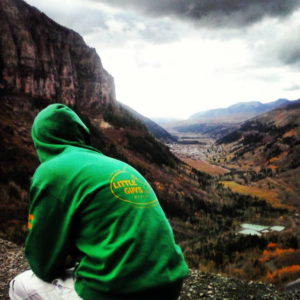 man in Little Guys Movers hoodie looking at canyon
