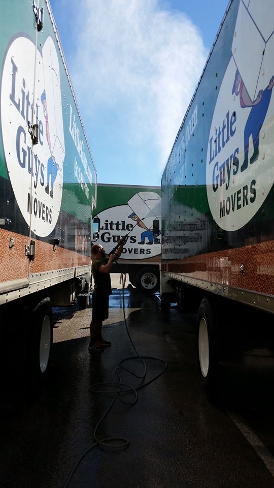 man powerwashing Little Guys Movers trucks