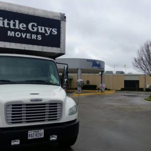 Little Guys Movers truck outside building