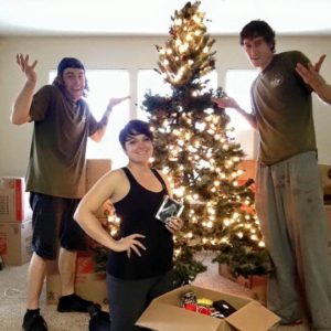 Little Guys Movers and a customer posing with a Christmas tree in Norman