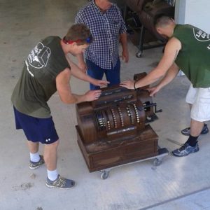 Two Little Guys moving an antique machine