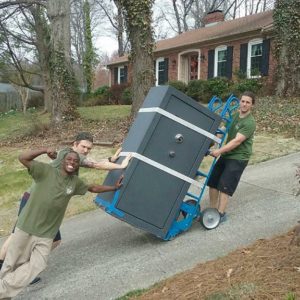 Little Guys Movers posing with a safe.