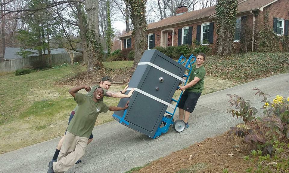 Little Guys Movers posing with a safe.