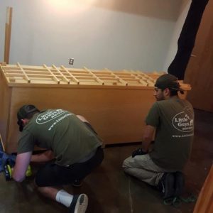 Little Guys Movers disassembling furniture.