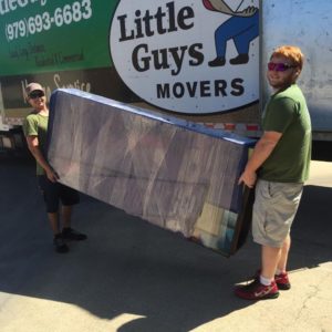 Two Little Guys Movers carrying furniture