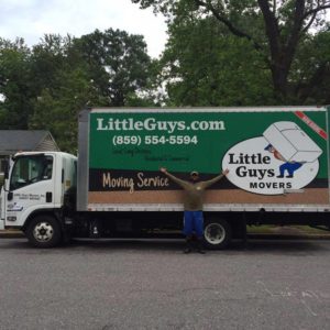 A mover poses with a Little Guys Movers truck