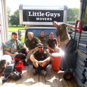 A Little Guys Movers crew in the back of a truck