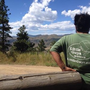 A mover standing on the side of a road with a scenic mountain view