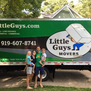 A happy family posing with a Little Guys truck