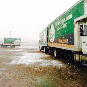 Little Guys Movers truck in a winter snow scene