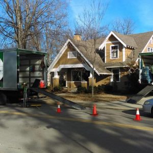 Two Little Guys trucks parked outside a house