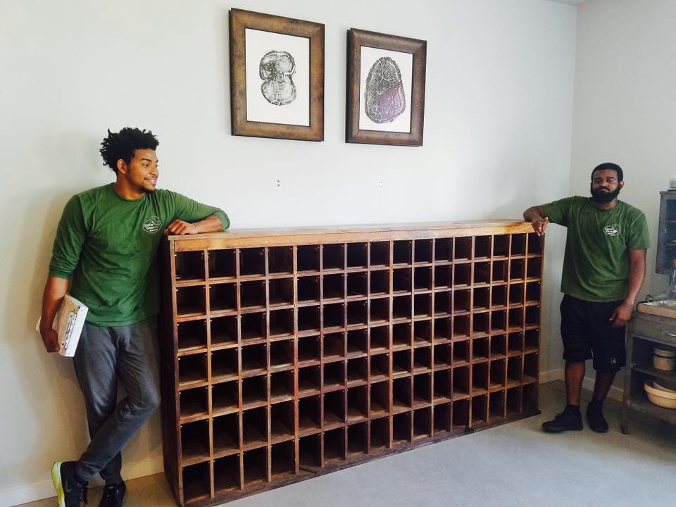 Two Little Guys pose with a giant 300 pound mail sorter cabinet