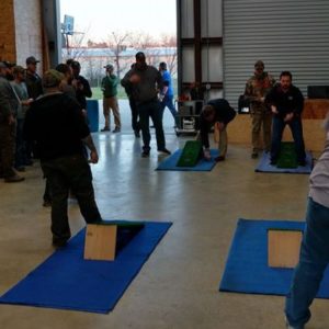 Little Guys playing bag toss together in a warehouse