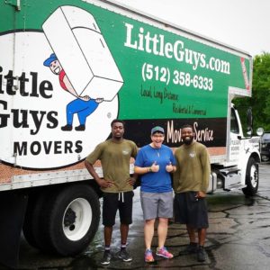 Little Guys Movers posing with a customer in front of a moving truck