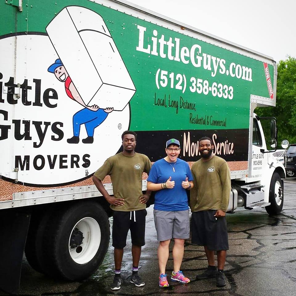 Little Guys movers smiling in the rain with a happy customer