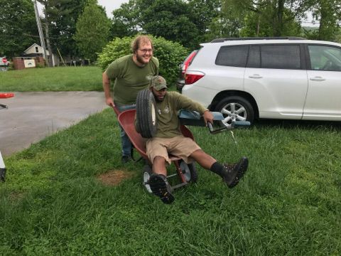 Two Little Guys having fun playing with a wheelbarrow