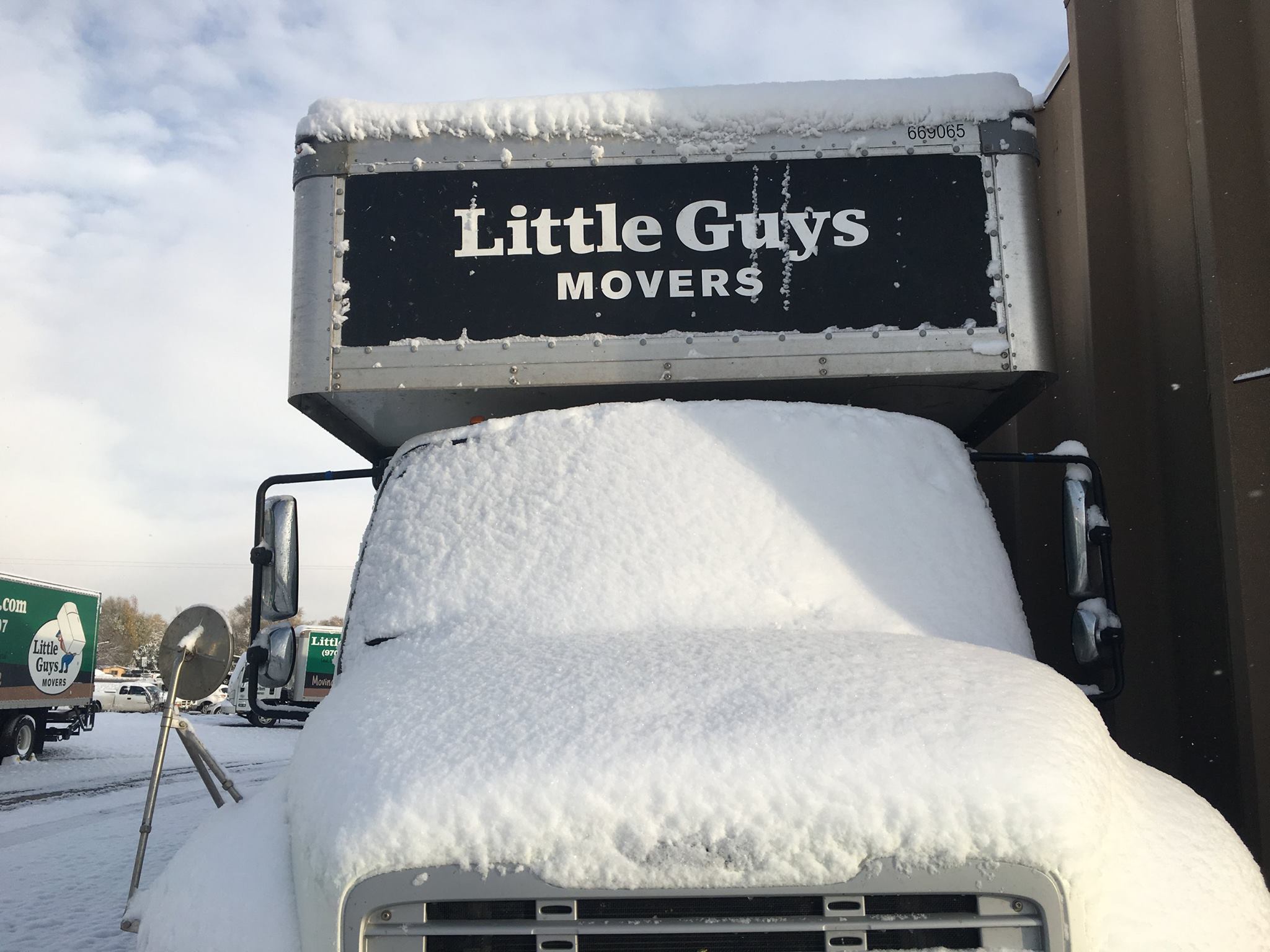 A Little Guys Movers truck covered in snow