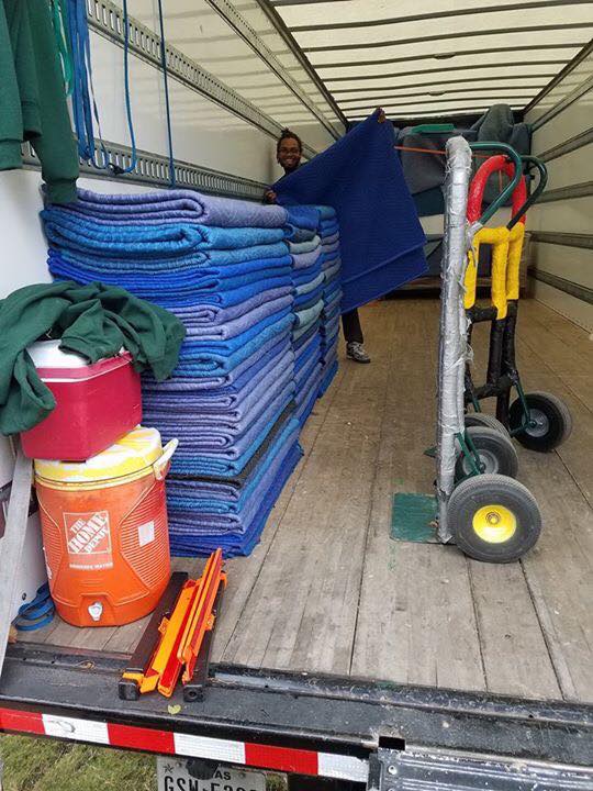 Mover in van folding moving blankets for Little Guys Movers Austin