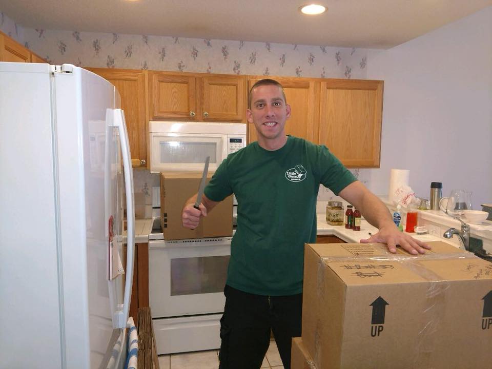 Mover in a kitchen preparing to open and unpack a box