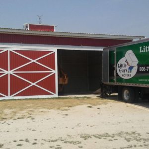lubbock movers moving truck in front of red barn