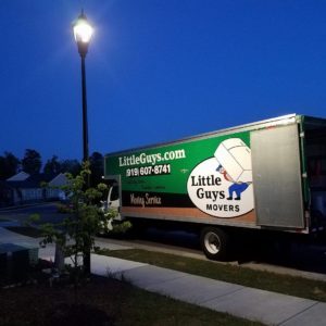 A Little Guys Movers truck outside of a home