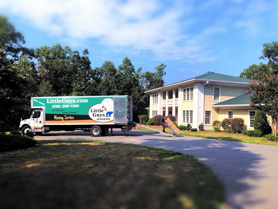A Greensboro Little Guys Movers truck outside home