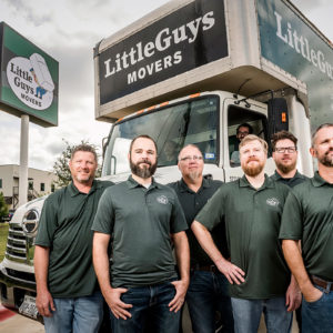 Little Guys Movers HQ staff stand in front of a moving truck