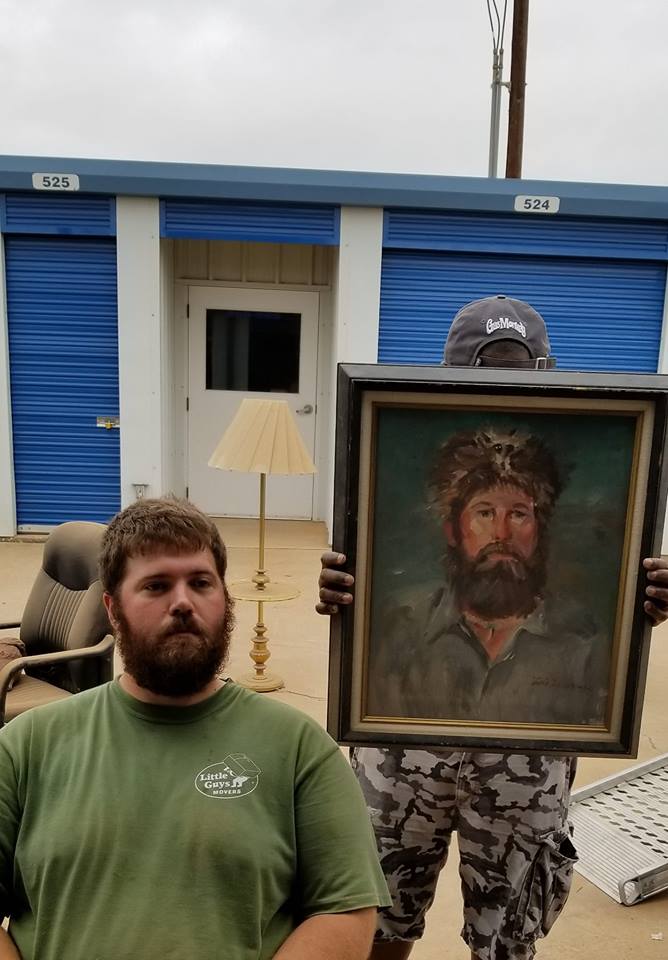 A mover posing with a painting that looks a lot like him!