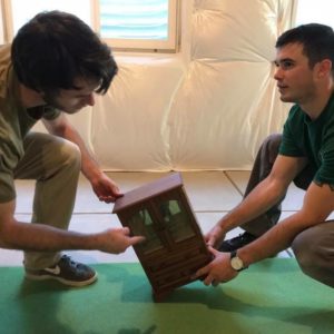 fort collins moving little guys movers holding miniature piece of furniture