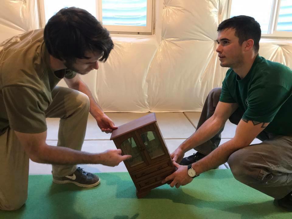 fort collins moving little guys movers holding miniature piece of furniture