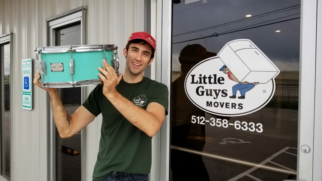 little guys mover employee holding snare drum