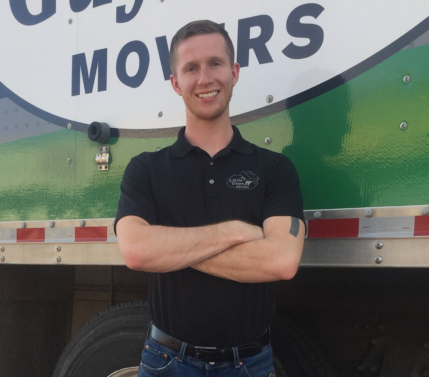 Lubbock Branch Manager Drew Brannon smiles in front of a Little Guys Movers moving truck.