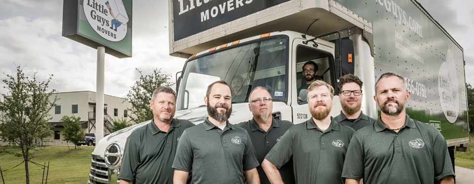 The Little Guys Movers Franchise Support team stands in front of their moving truck in Denton, Texas.