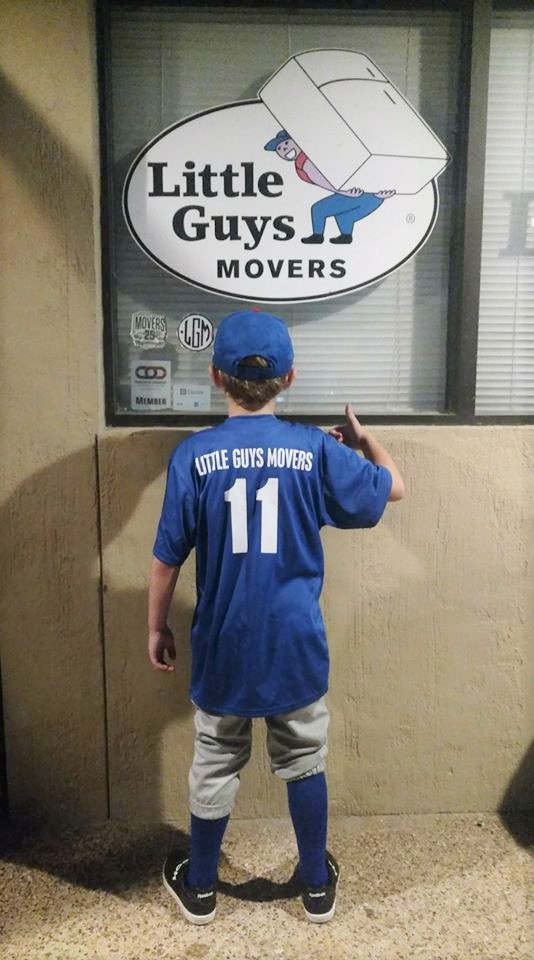 Little League player with Little Guys Movers on the back of shirt