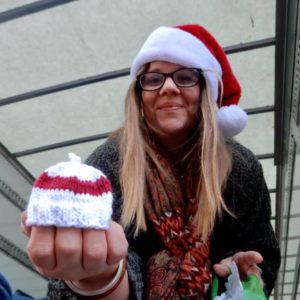 Mover in Santa hat holding small hat for a baby