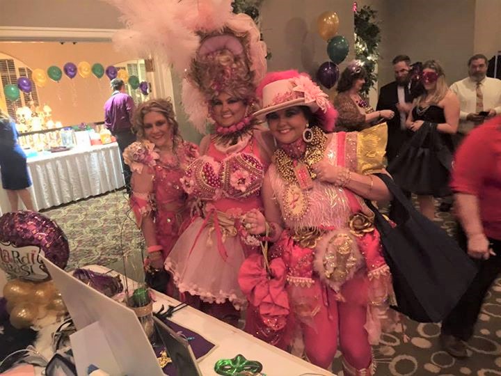 Three women in pink Mardi Gras outfits at the Mardi Paws Gala