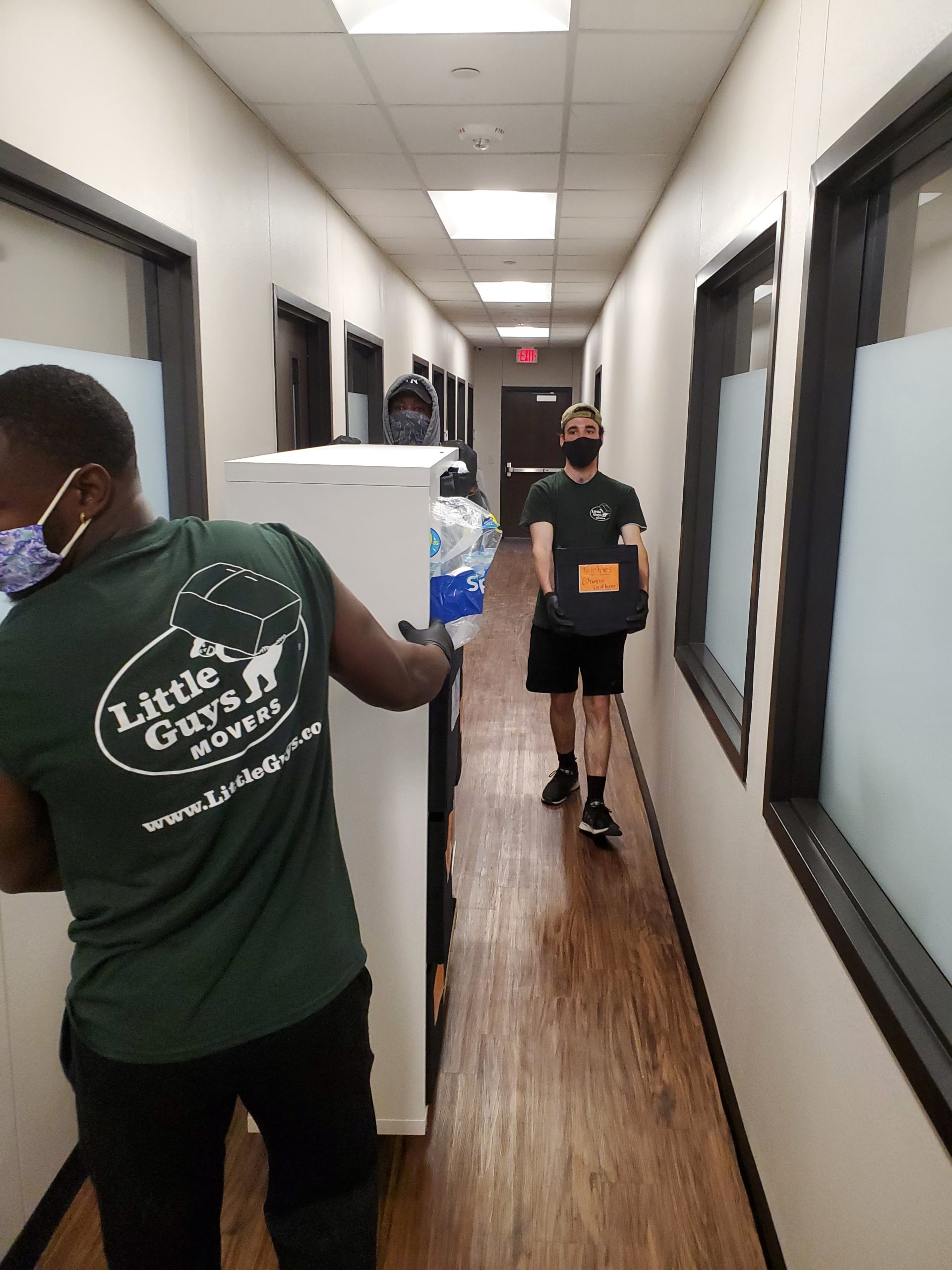 Little Guys Movers employees moving boxes in Grace Like Rain office