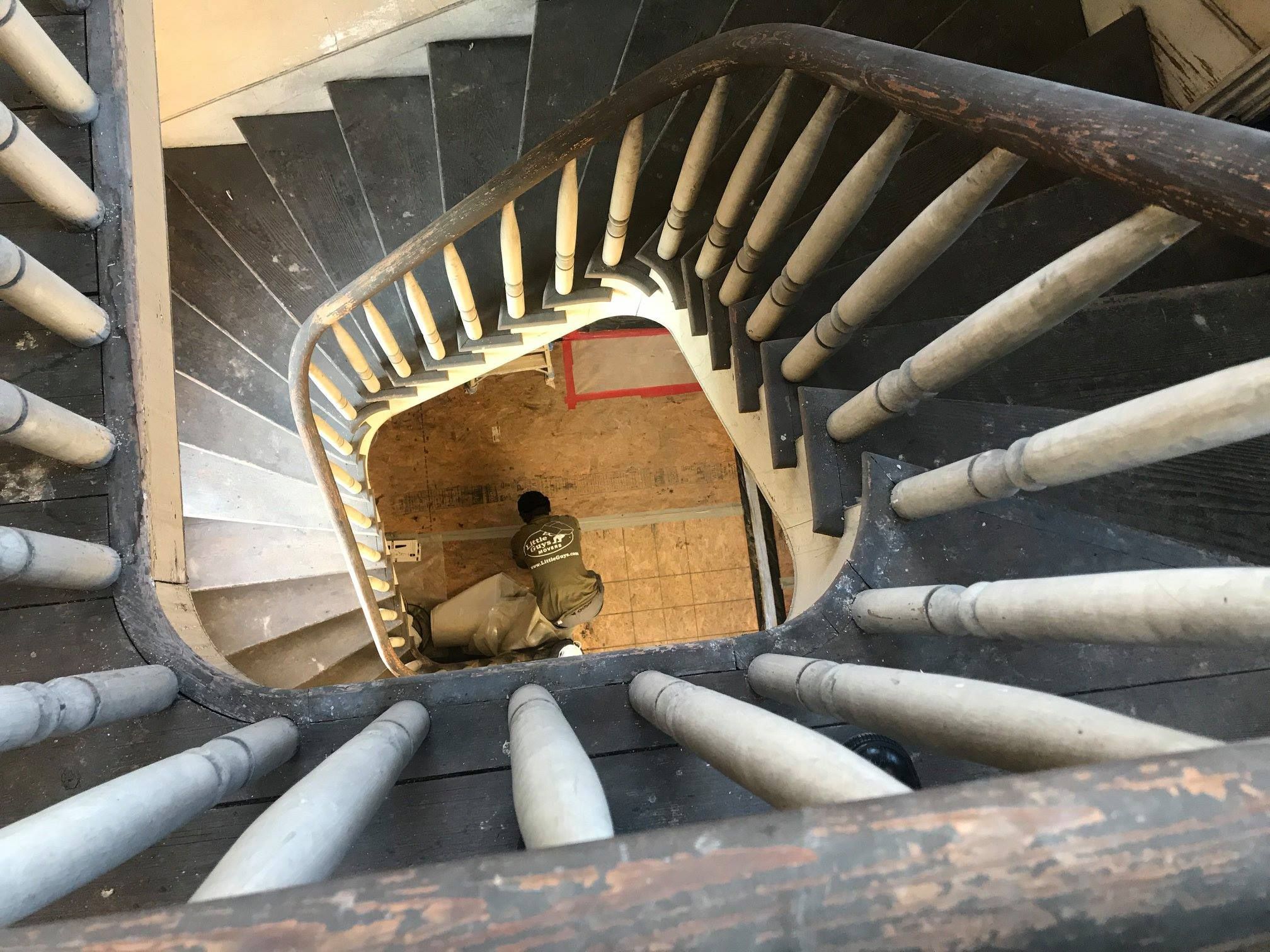 Staircase viewed from above with Little Guy employee at the bottom