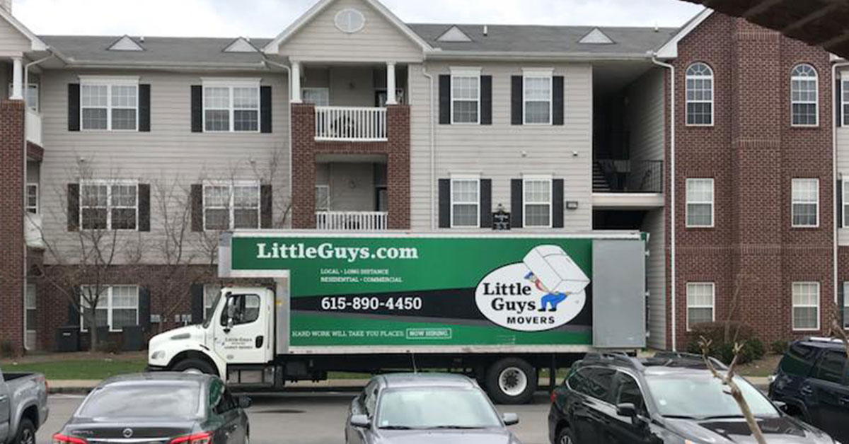 Little Guys Movers apartment moving truck in front of building