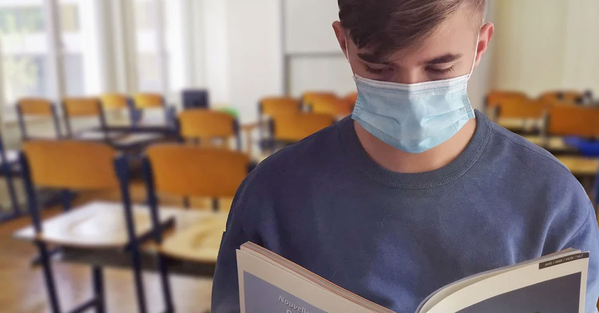 Student wearing mask reading in school