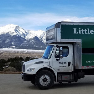 Little Guys Movers moving truck in foreground with the beautiful Fort Collins mountains in the background