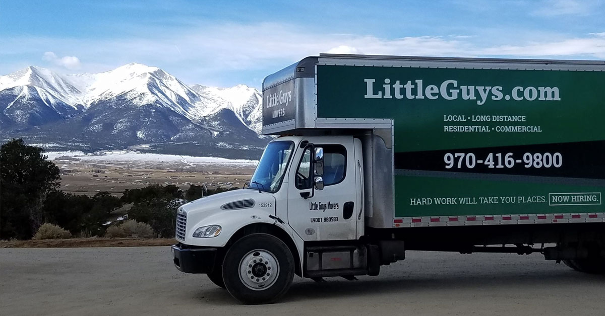Little Guys Movers moving truck in foreground with the beautiful Fort Collins mountains in the background