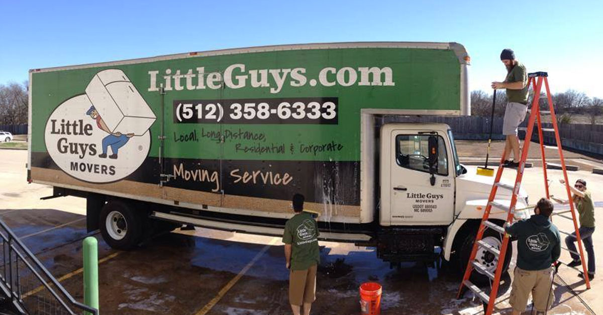 Four Little Guys movers wash a moving truck in Austin, TX